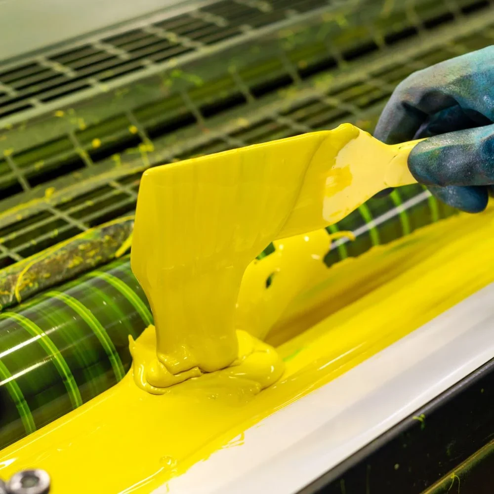 Print-shop-worker-loading-ink-into-machine.jpg